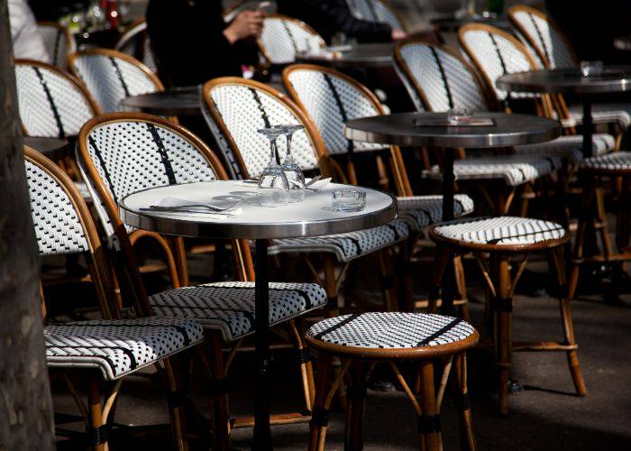 An al fresco dining area with black-and-white patio furniture and small, round tables.